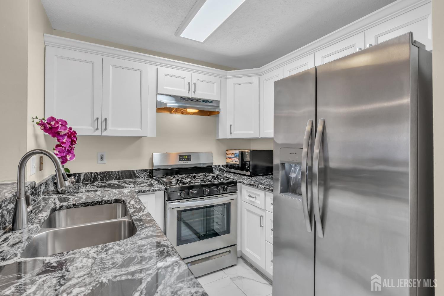 1014 Edpas Road New Brunswick, NJ 08901 - Photo 10 of 27 a kitchen with stainless steel appliances granite countertop a sink stove and refrigerator