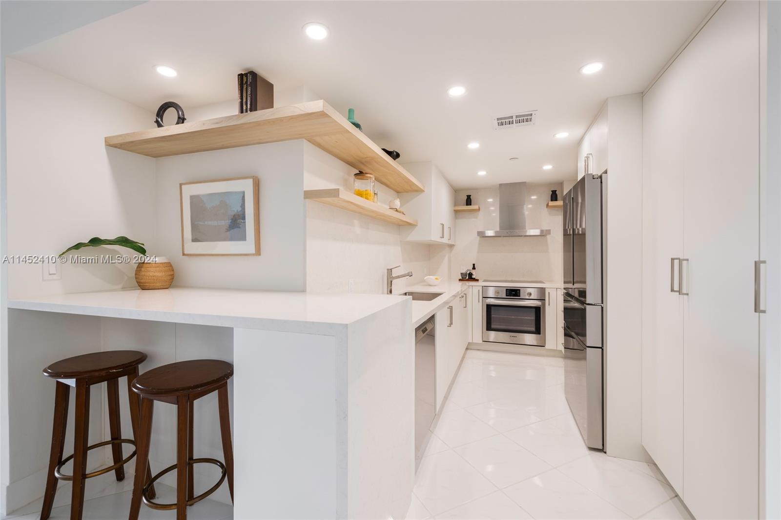 a kitchen with stainless steel appliances a sink cabinets and wooden floor