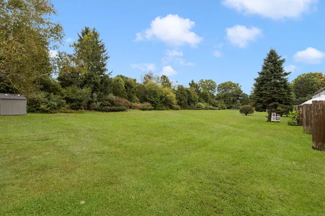a view of a green field with wooden fence