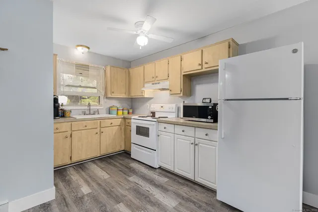 a kitchen with white cabinets and white appliances