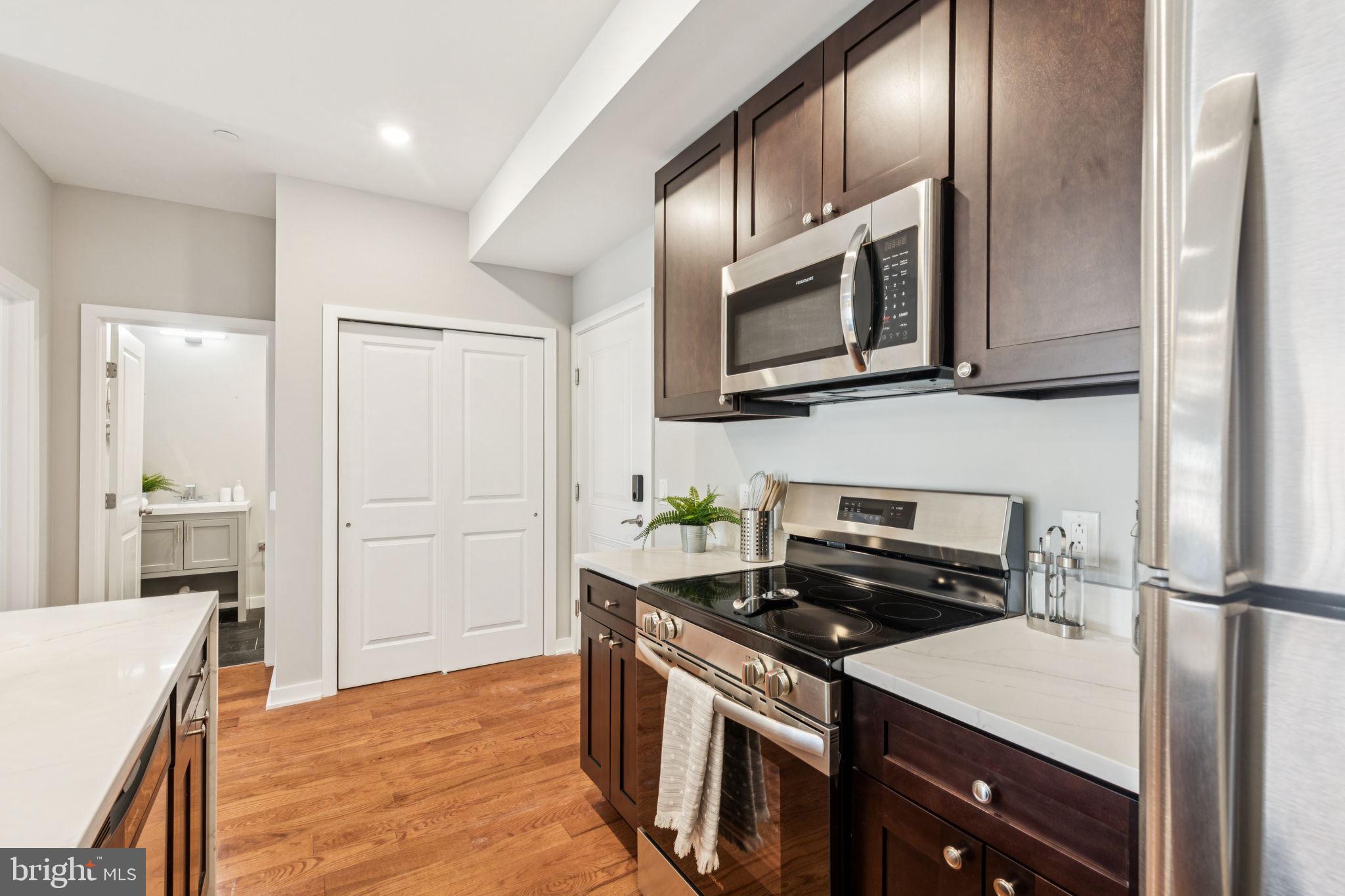 203 Haverford Avenue, Unit 208 Narberth, PA 19072 - Photo 7 of 35 a kitchen with stainless steel appliances granite countertop a stove a refrigerator and a microwave