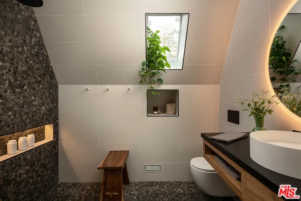 a bathroom with a toilet a sink and a mirror