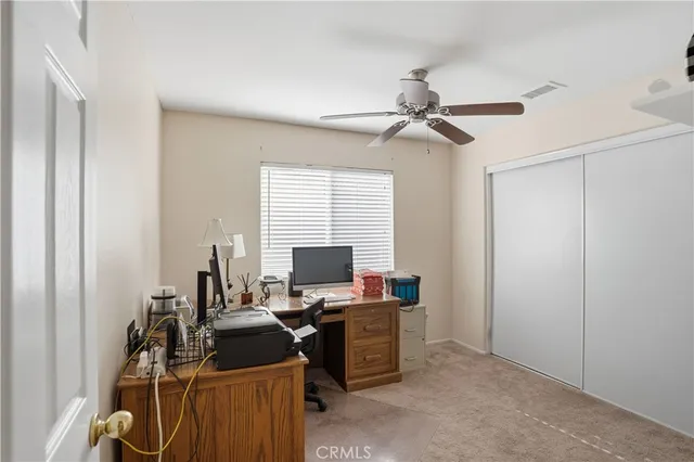 a view of a livingroom with a furniture ceiling fan and window