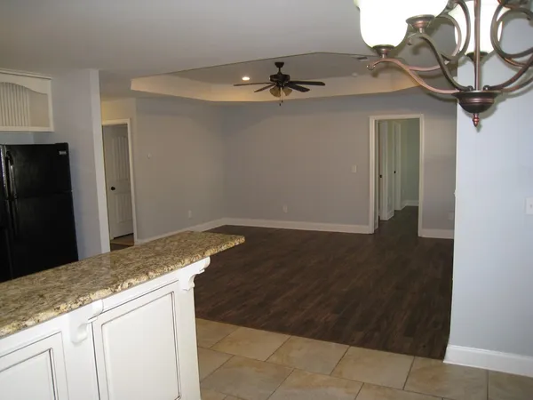 a kitchen with granite countertop a refrigerator stove top oven and sink