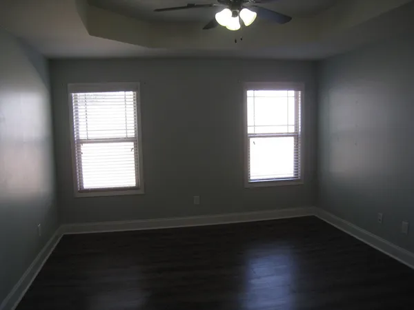 a view of a room with wooden floor and small window
