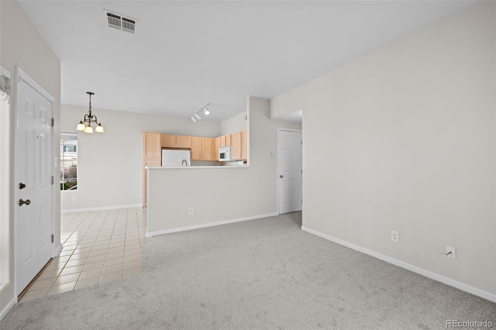 8389 Pebble Creek Way, Unit 101 Highlands Ranch, CO 80126 - Photo 12 of 44 an empty room with kitchen and windows