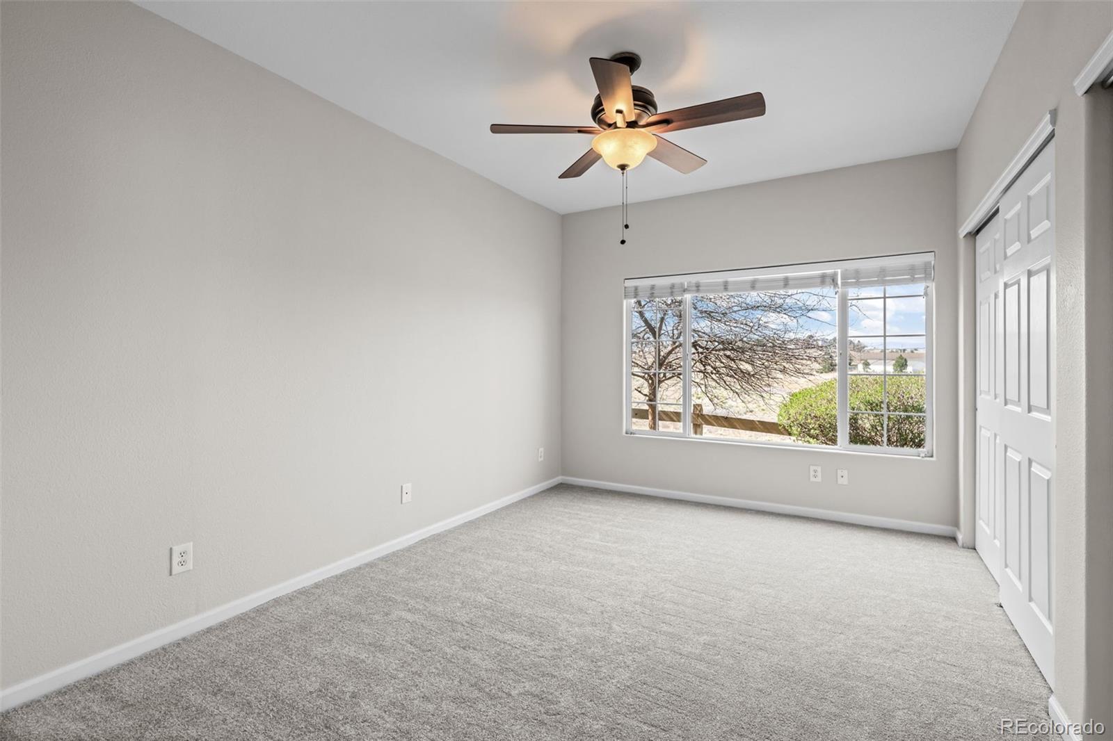 8389 Pebble Creek Way, Unit 101 Highlands Ranch, CO 80126 - Photo 20 of 44 an empty room with window ceiling fan and windows
