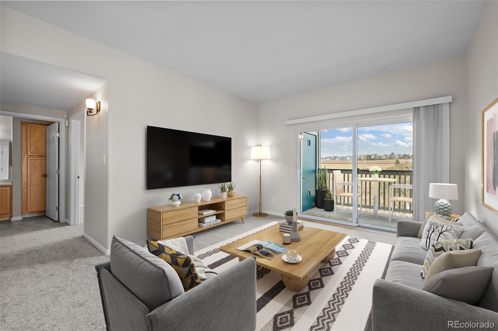 8389 Pebble Creek Way, Unit 101 Highlands Ranch, CO 80126 - Photo 3 of 44 a living room with furniture and a flat screen tv