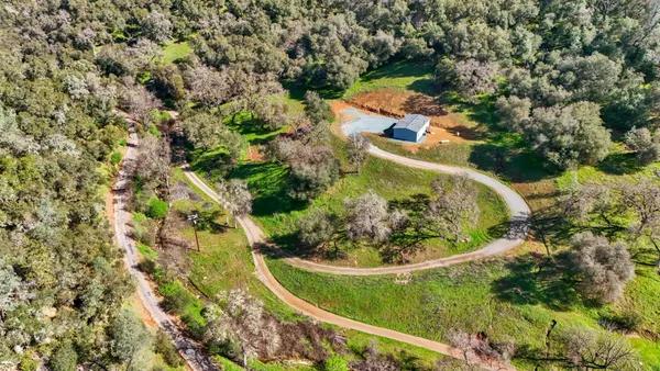 an aerial view of a house with a yard and trees