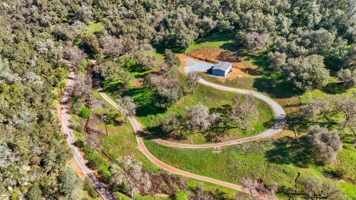 an aerial view of a house with a yard and trees