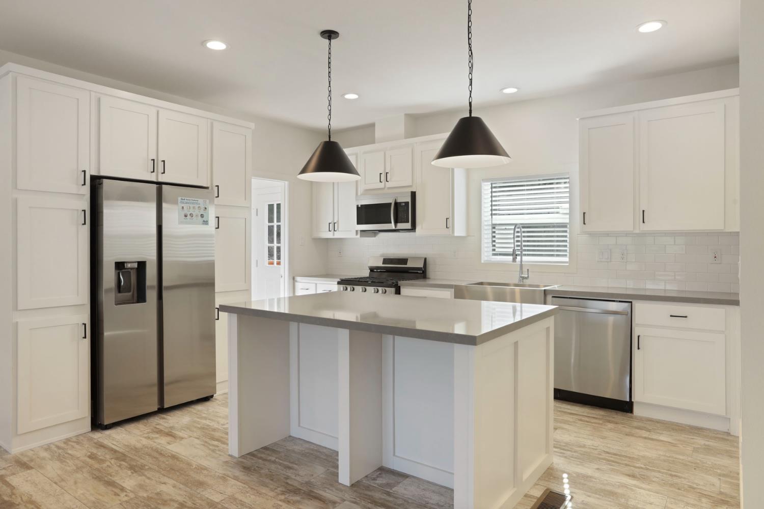 7680 Middle Bar Road Jackson, CA 95642 - Photo 23 of 58 a kitchen with stainless steel appliances granite countertop a sink a stove a refrigerator and island with wooden floor