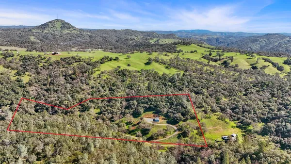 an aerial view of a house with a yard and outdoor seating