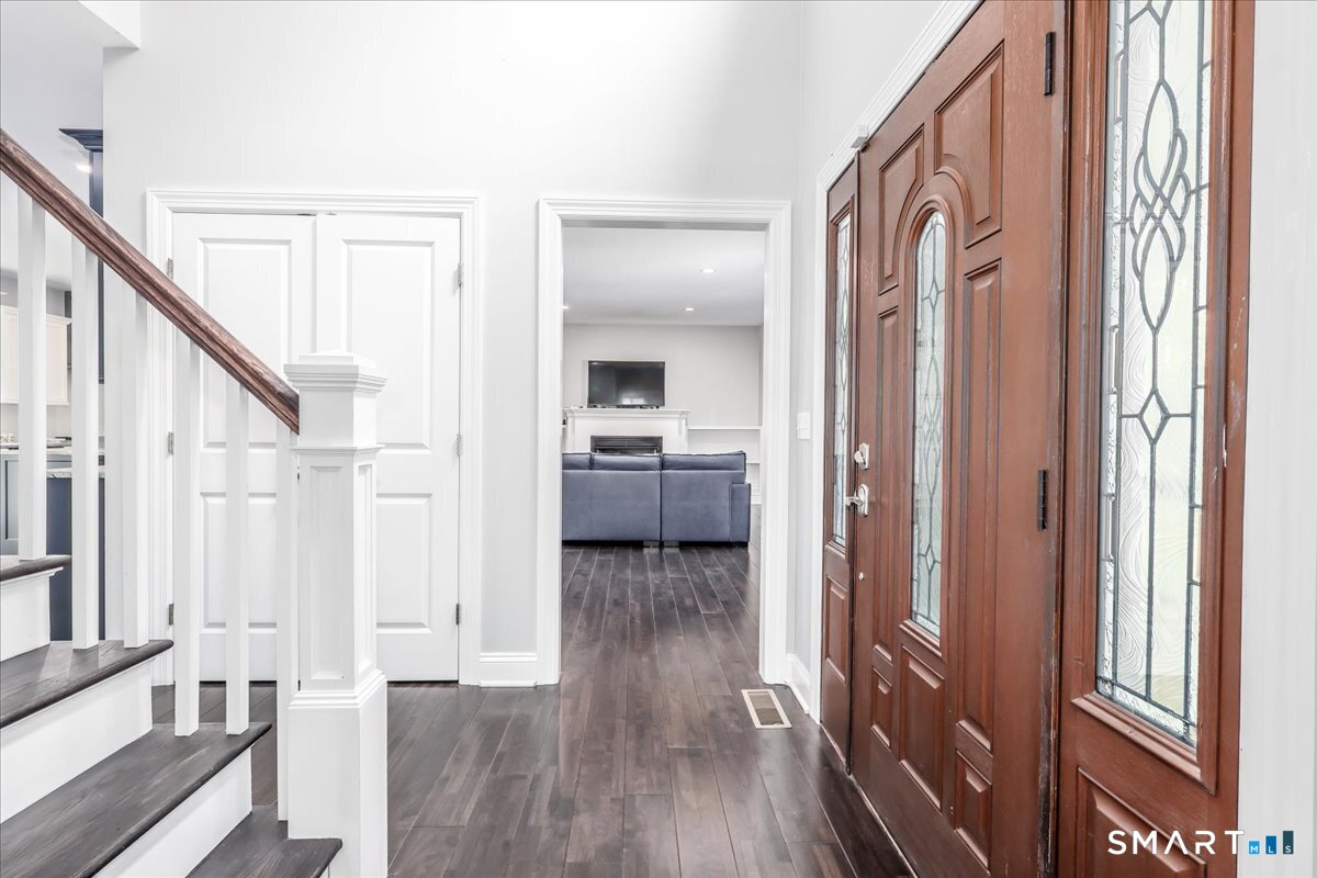 127 Putnam Park Road Bethel, CT 06801 - Photo 6 of 35 a view of a hallway with wooden floor and staircase