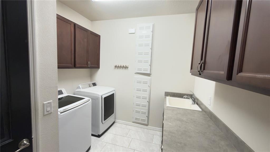 7360 Pool Compass Loop Wesley Chapel, FL 33545 - Photo 12 of 54 a view of storage and utility room with washer and dryer