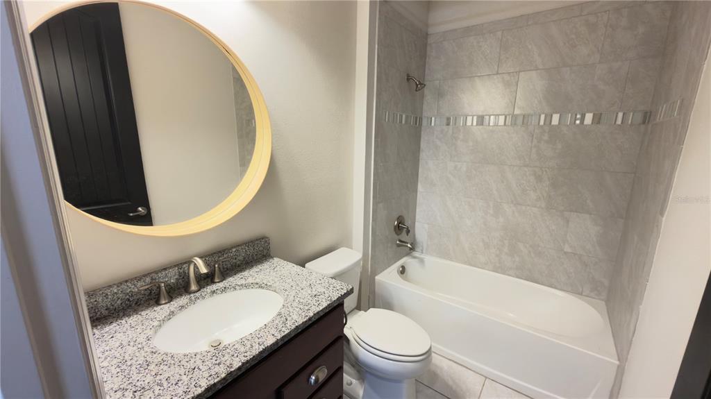 7360 Pool Compass Loop Wesley Chapel, FL 33545 - Photo 14 of 54 a bathroom with a granite countertop sink toilet and shower