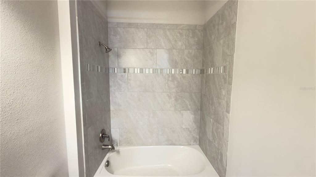 7360 Pool Compass Loop Wesley Chapel, FL 33545 - Photo 15 of 54 a bathroom with a tub and shower