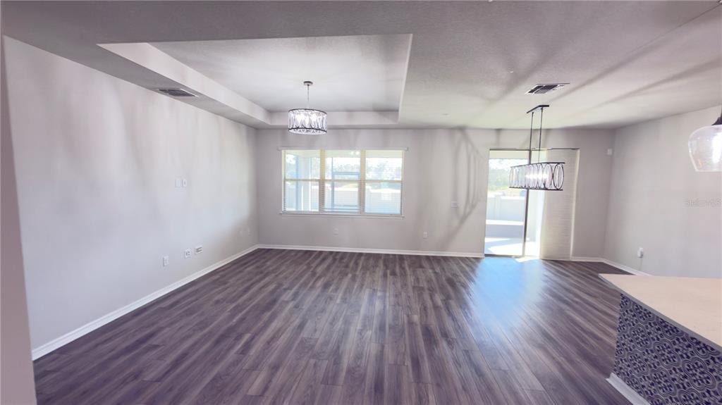 7360 Pool Compass Loop Wesley Chapel, FL 33545 - Photo 18 of 54 an empty room with wooden floor and windows
