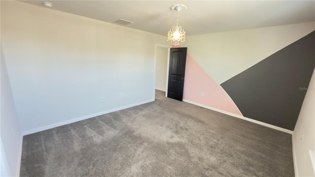 7360 Pool Compass Loop Wesley Chapel, FL 33545 - Photo 38 of 54 a view of an empty room with a chandelier fan