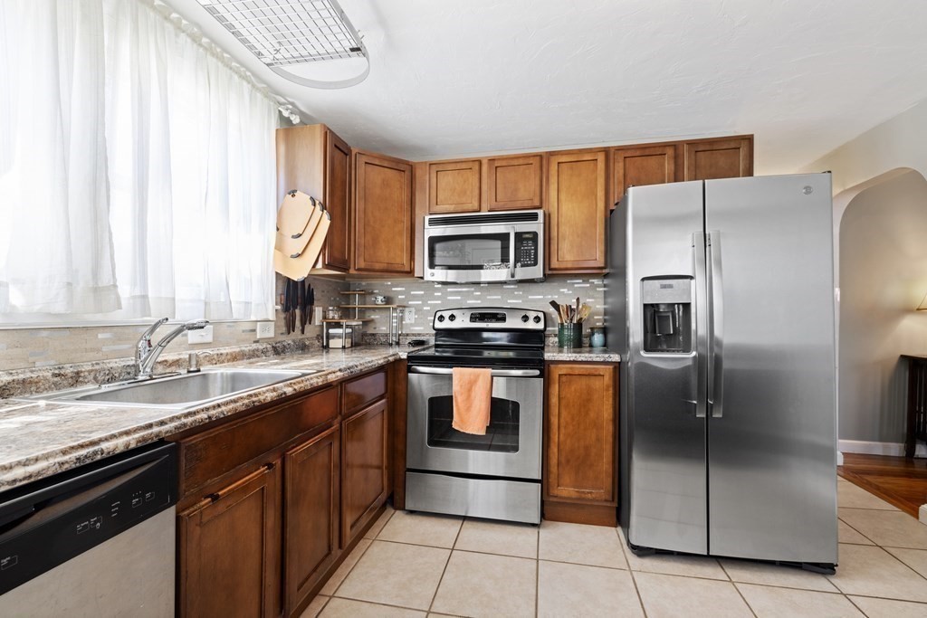 3 Pine Road Randolph, MA 02368 - Photo 7 of 30 a kitchen with stainless steel appliances granite countertop a refrigerator stove and microwave