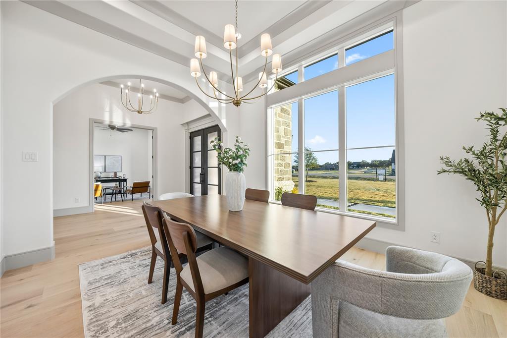 724 Cooper Trail Weatherford, TX 76087 - Photo 4 of 37 Dining area featuring a coffered ceiling, large picture windows, light wood-finish flooring, and an arched entryway