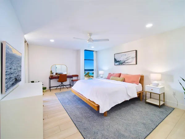 a spacious bedroom with a bed a table and painting