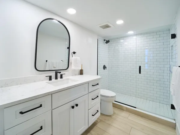 a bathroom with a double vanity sink toilet and a mirror