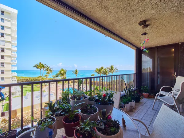 a view of a balcony with chairs and potted plants