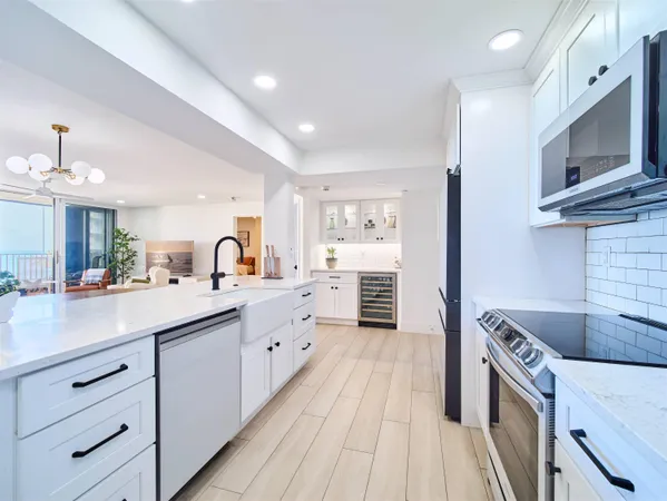 a kitchen with cabinets wooden floor and stainless steel appliances