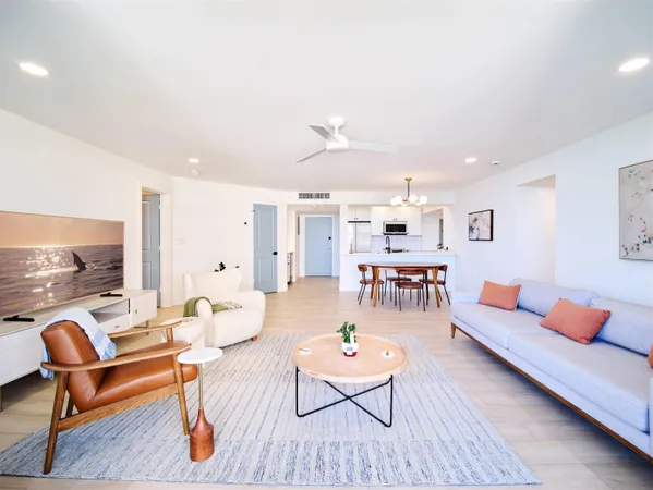 a living room with furniture kitchen view and a large window