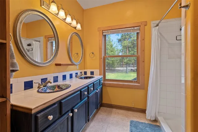 a bathroom with a granite countertop sink a mirror and a window