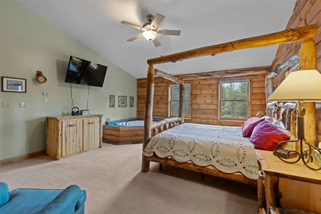 a bedroom with bed and a flat tv screen