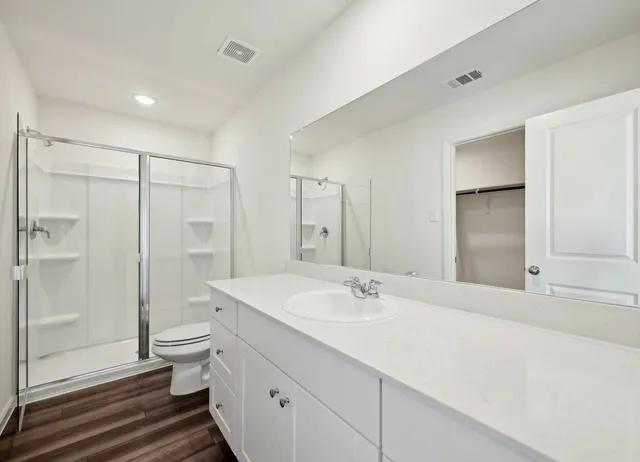 a bathroom with a double vanity sink toilet and shower