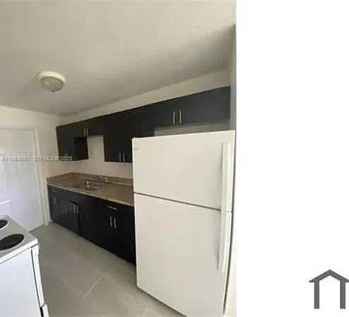 a kitchen with stainless steel appliances granite countertop a refrigerator and a stove