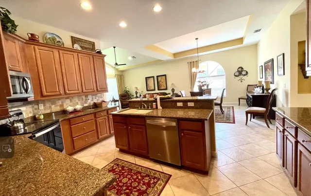 a large kitchen with stainless steel appliances granite countertop a sink and cabinets
