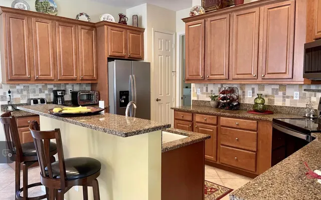 a kitchen with stainless steel appliances granite countertop a sink refrigerator and cabinets