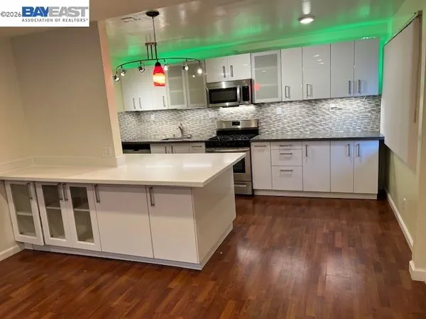 a kitchen with stainless steel appliances granite countertop a stove a sink and a microwave