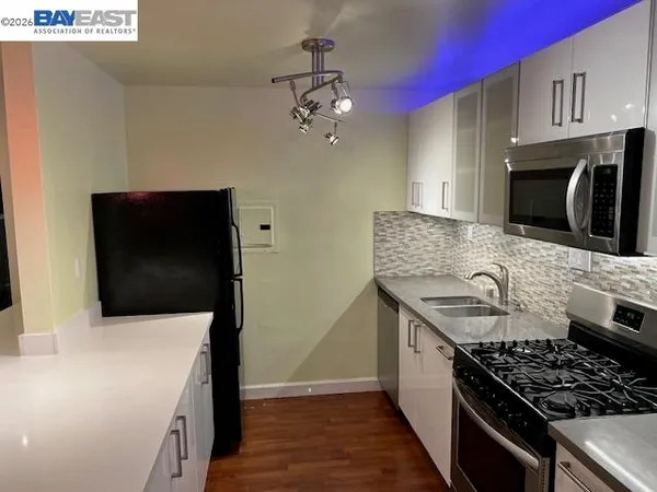 a kitchen with stainless steel appliances a stove a microwave and sink