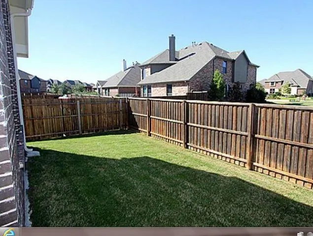 a view of a house with a small yard and a fence