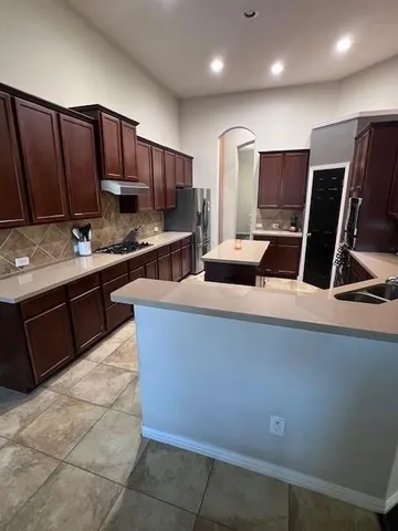 a kitchen with stainless steel appliances granite countertop a stove a sink and a refrigerator