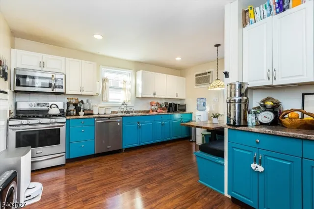 a kitchen with granite countertop wooden floors and white stainless steel appliances