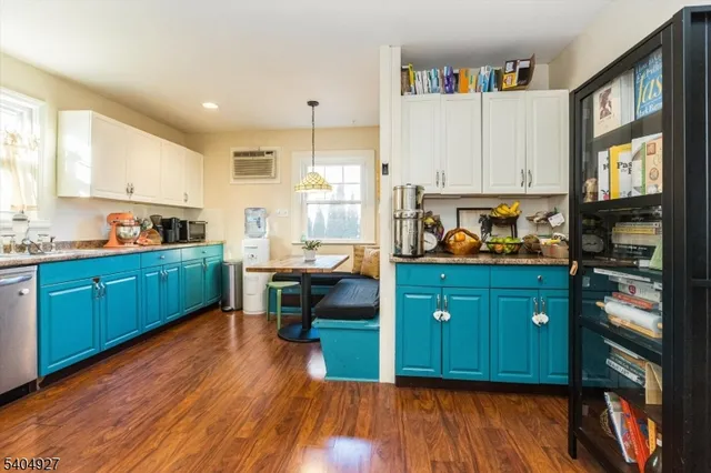 a kitchen with wooden floor and cabinets