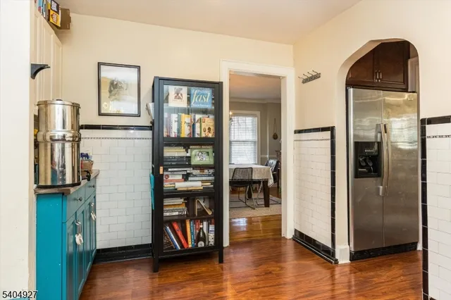 a view of a kitchen with fridge and wooden floor