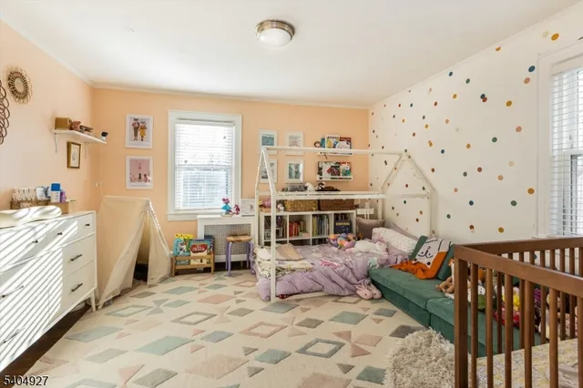 a living room with furniture and baby crib