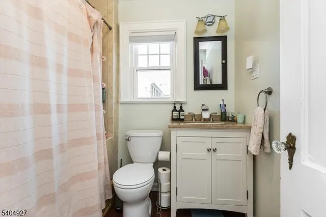a bathroom with a granite countertop toilet sink and mirror