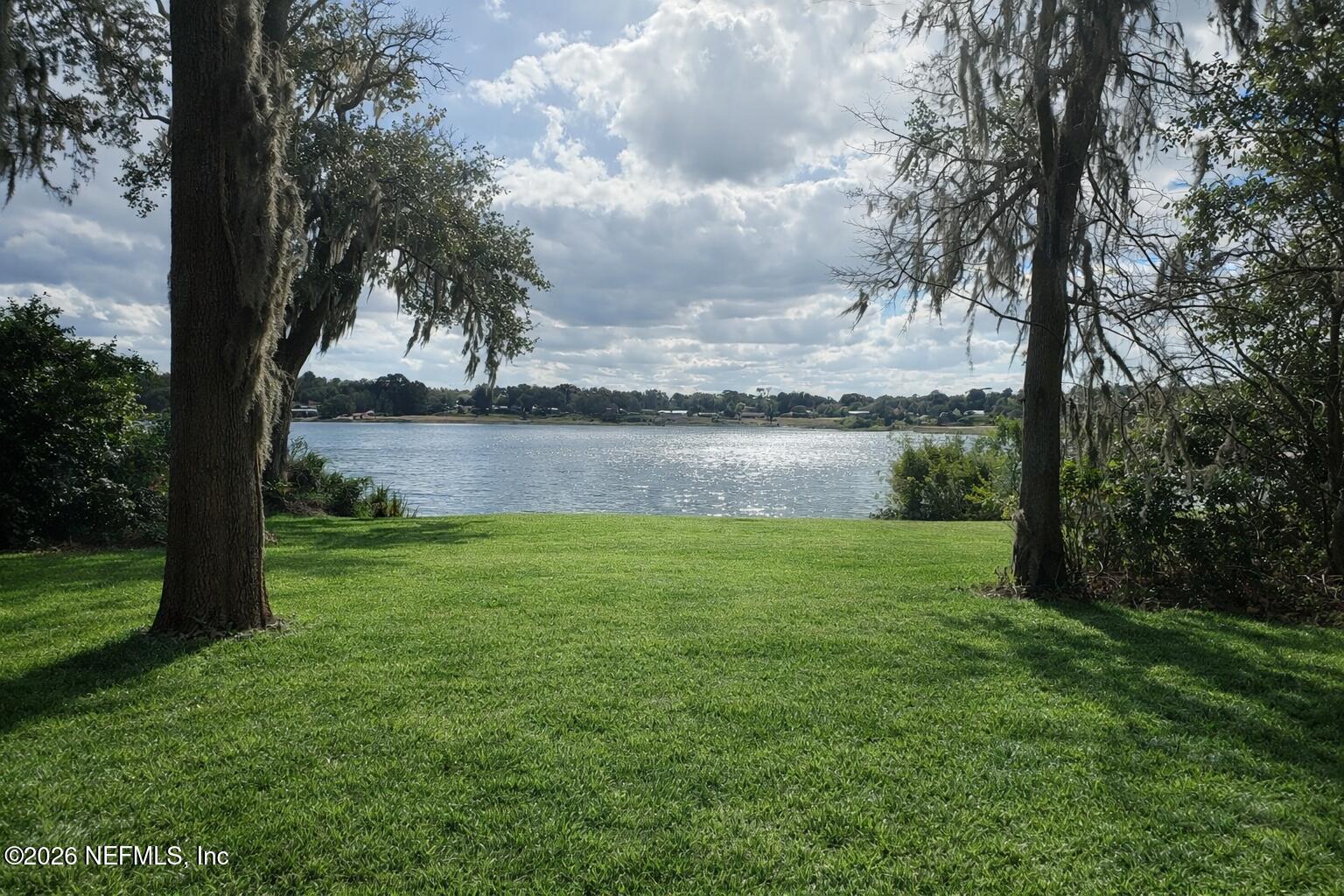 7873 State Road 21 Keystone Heights, FL 32656 - Photo 2 of 16 a view of a lake with a big yard and large trees