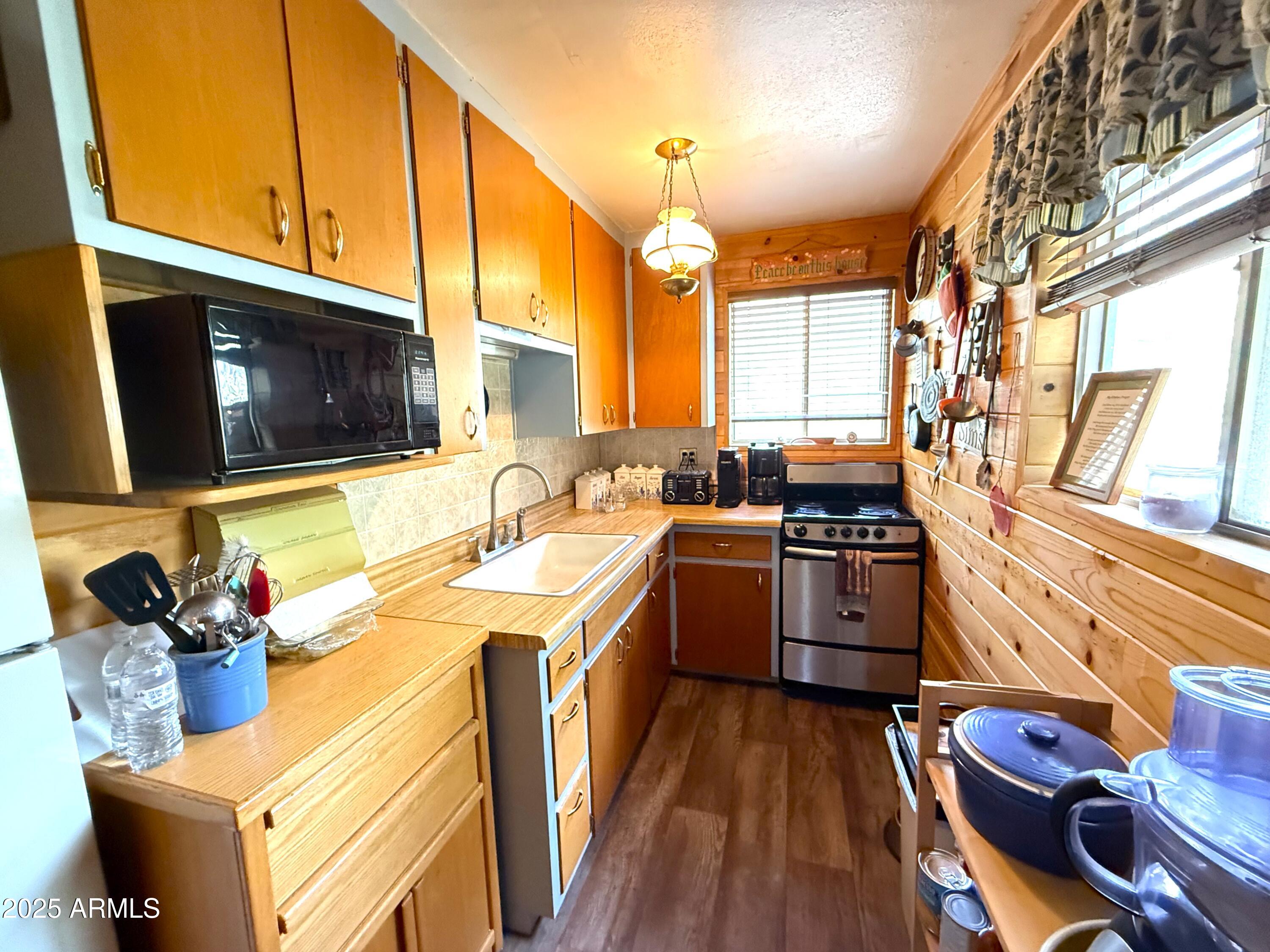 23298 South Towers Mountain Road Crown King, AZ 86343 - Photo 12 of 27 a kitchen with stainless steel appliances kitchen island granite countertop a sink stove and wooden floor