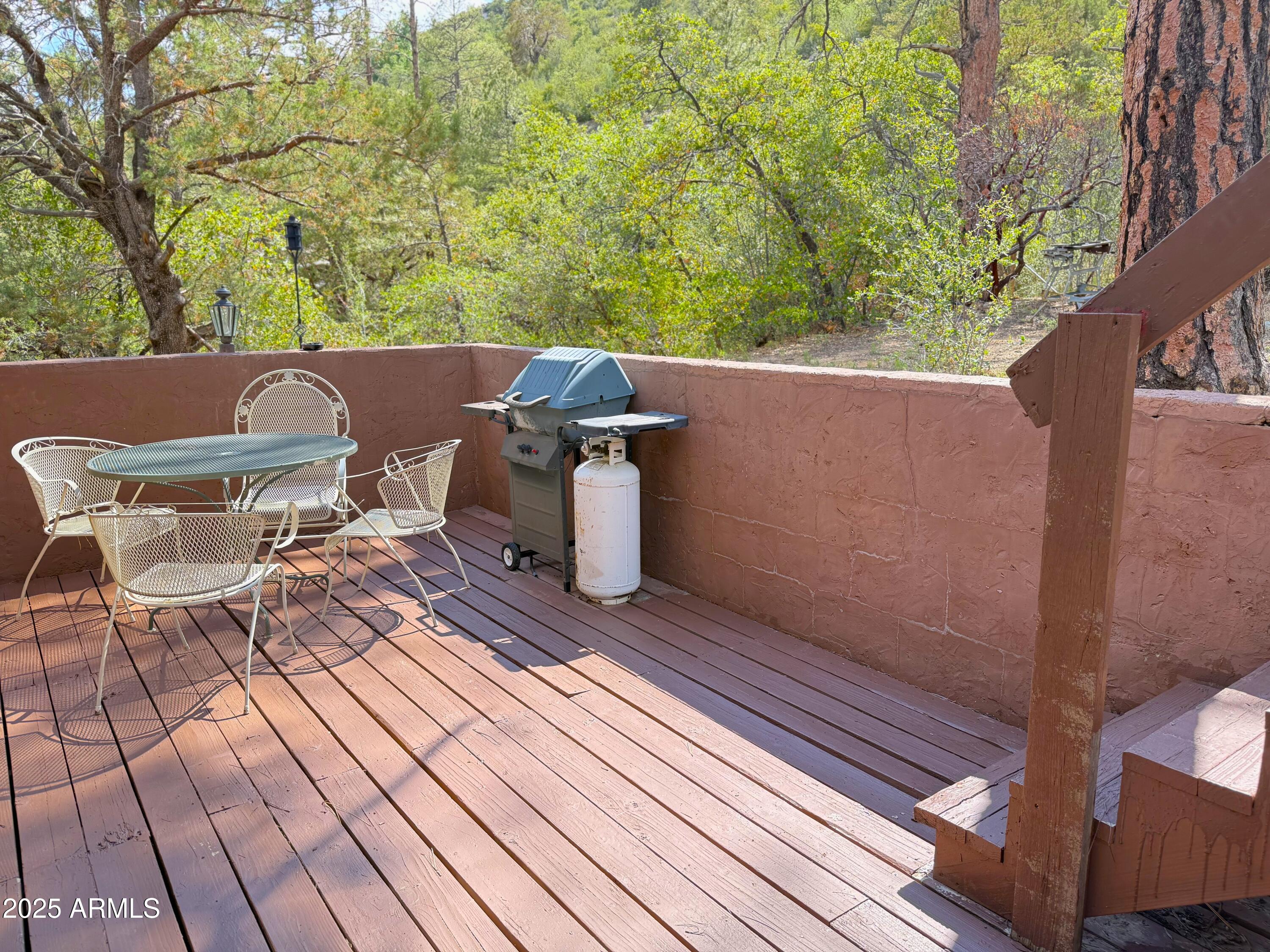 23298 South Towers Mountain Road Crown King, AZ 86343 - Photo 23 of 27 a view of a patio with table and chairs with wooden floor and fence
