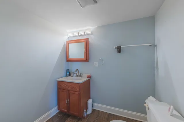 a bathroom with a toilet sink vanity and mirror