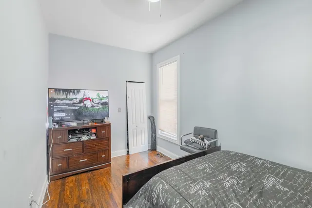 a bedroom with a bed and wooden floor