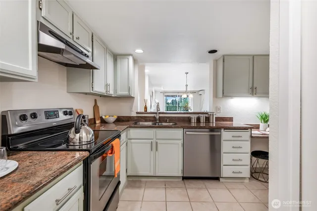 a kitchen with stainless steel appliances granite countertop a stove sink and cabinets